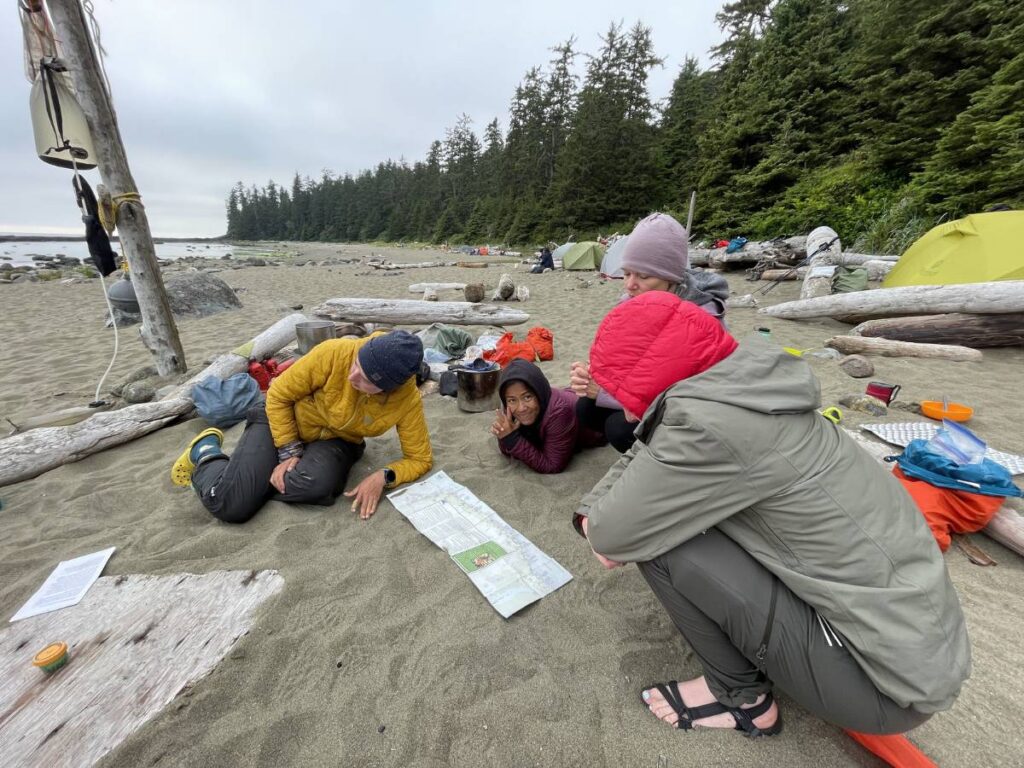 Hikers on the beach studying a map