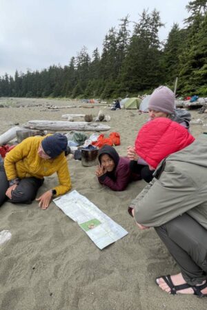 Hikers on the beach studying a map
